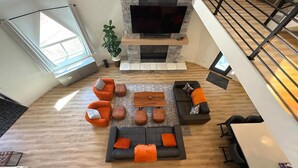 A spacious living area with a fireplace, comfortable seating, and a large window providing natural light. - The Dome Home | 8 mins from Kanarra Falls (New Harmony)