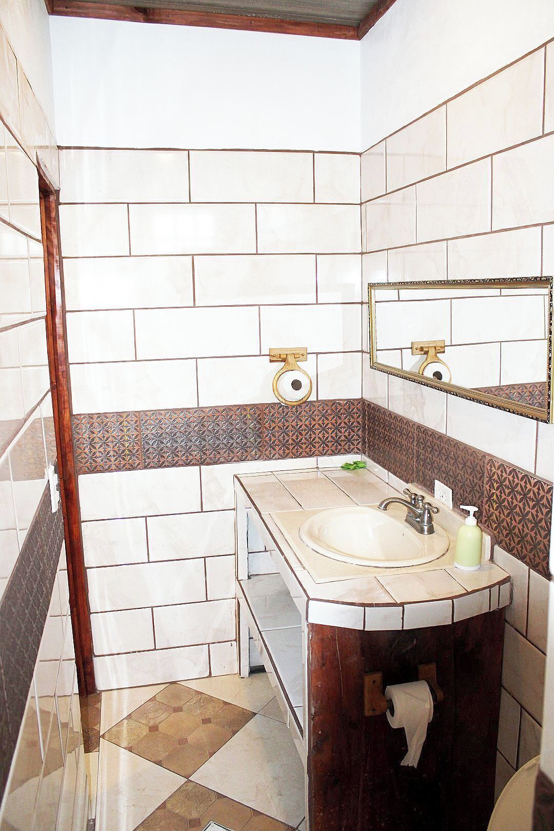 A bathroom with a sink, mirror, and toilet.