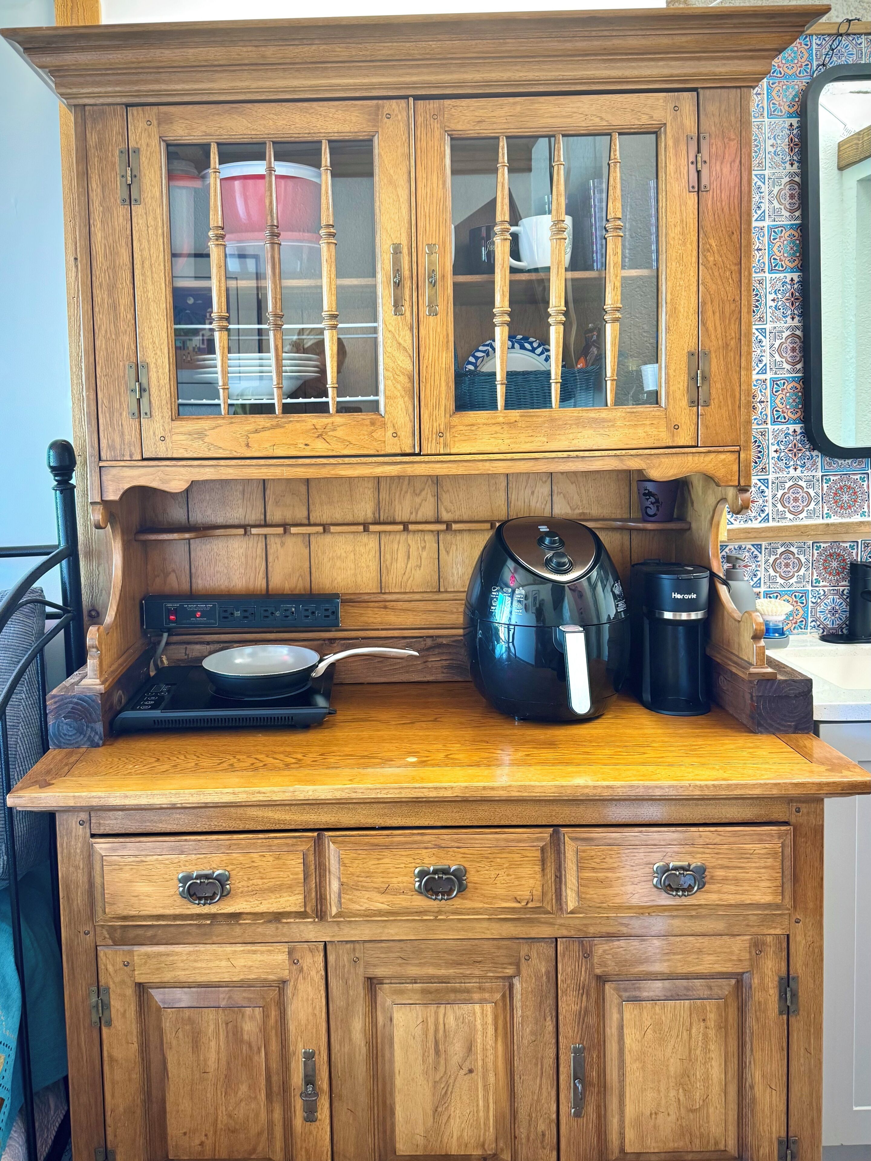 A wooden kitchen with a stove, a kettle, and a coffee maker.