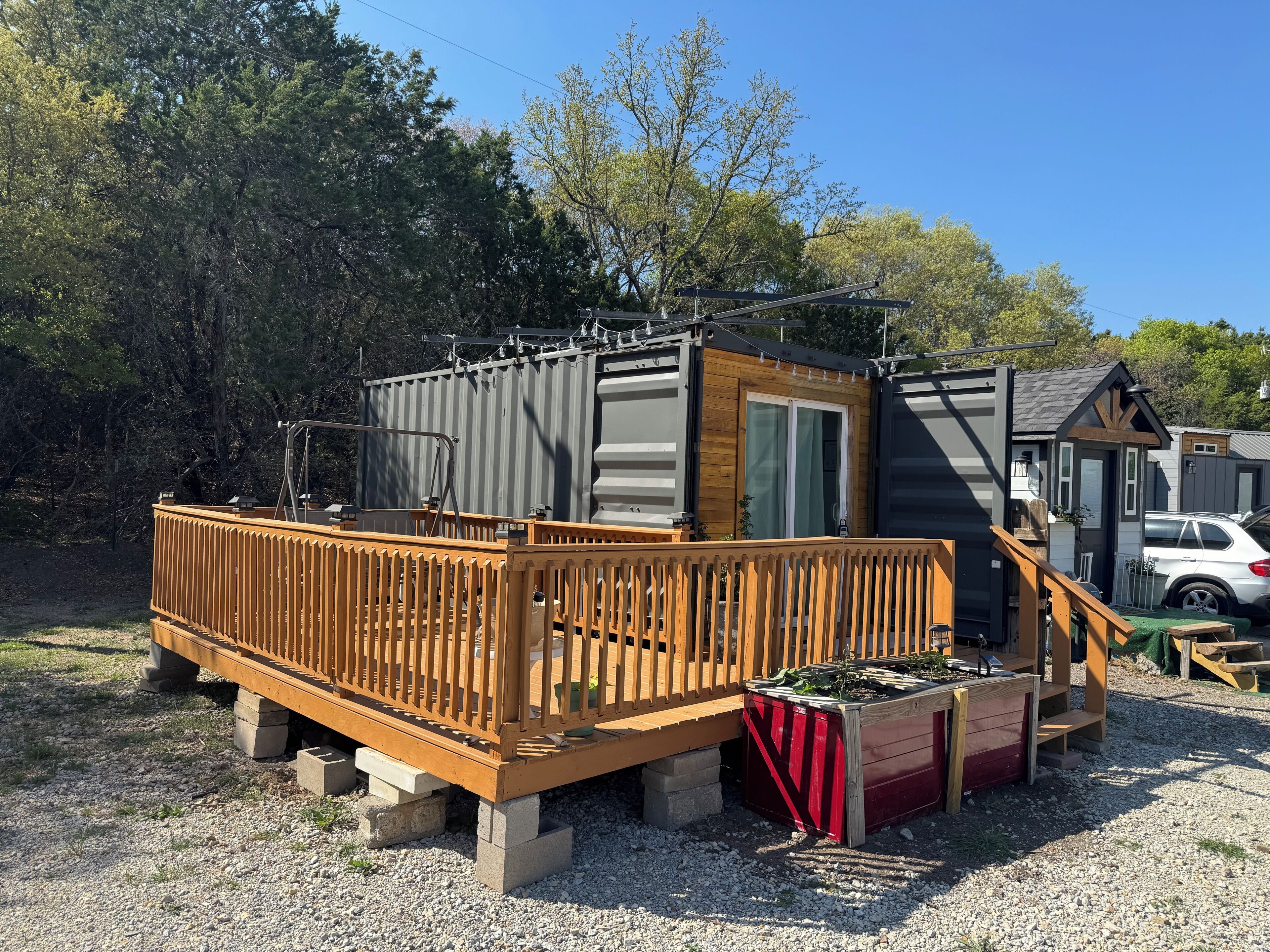 A small, single-story structure with a wooden deck and a sliding door.