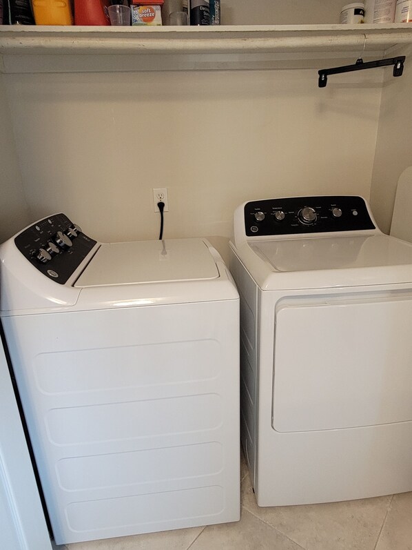 A laundry area with two white washing machines, one with a control panel and the other with dials, and a power outlet on the wall. - Timberlake Rd 7 mins to L.U. Terrific Townhome (Lynchburg)