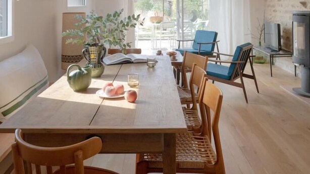 A dining area with a wooden table, chairs, and a hanging light fixture. - Le Petit Civry - SAINT JULIEN DE CIVRY (SAINT JULIEN DE CIVRY)