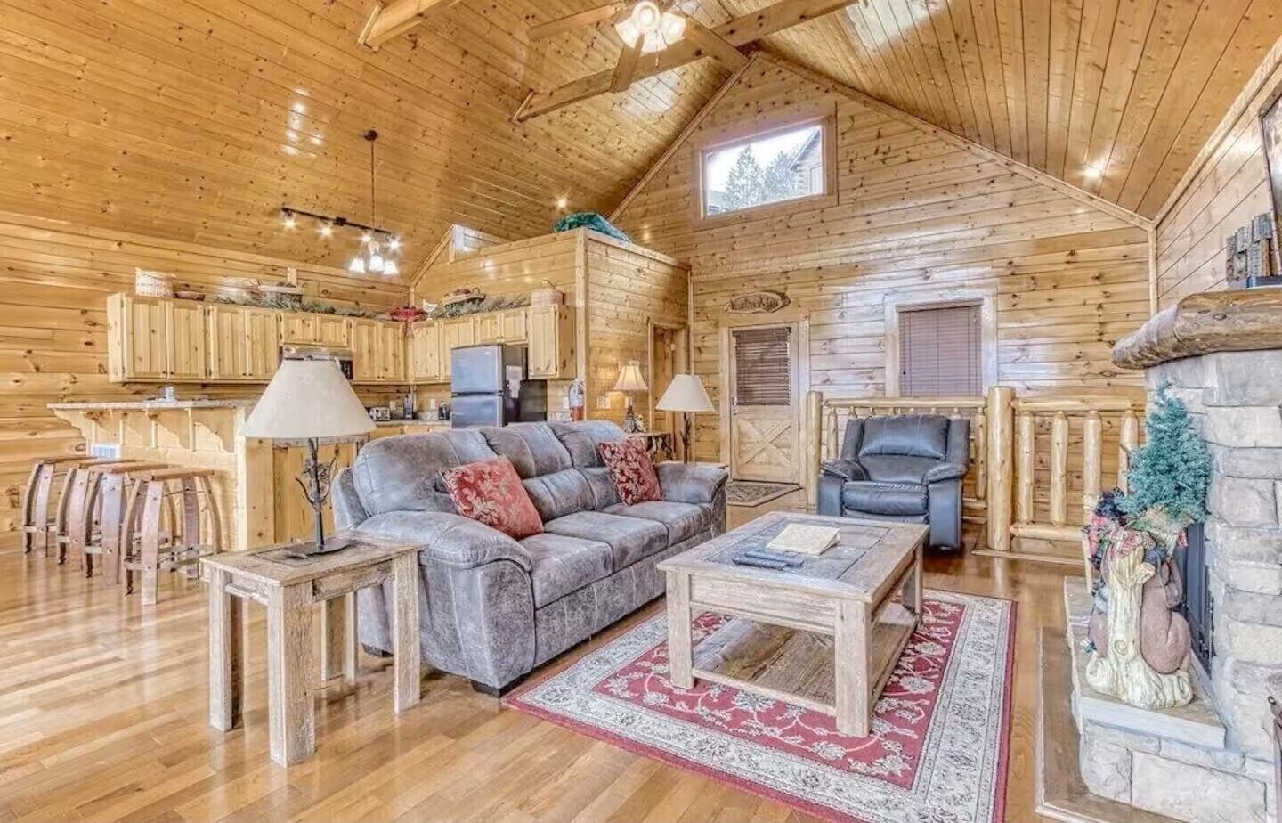 Interior acogedor de una cabaña de troncos con sala de estar, cocina y comedor.