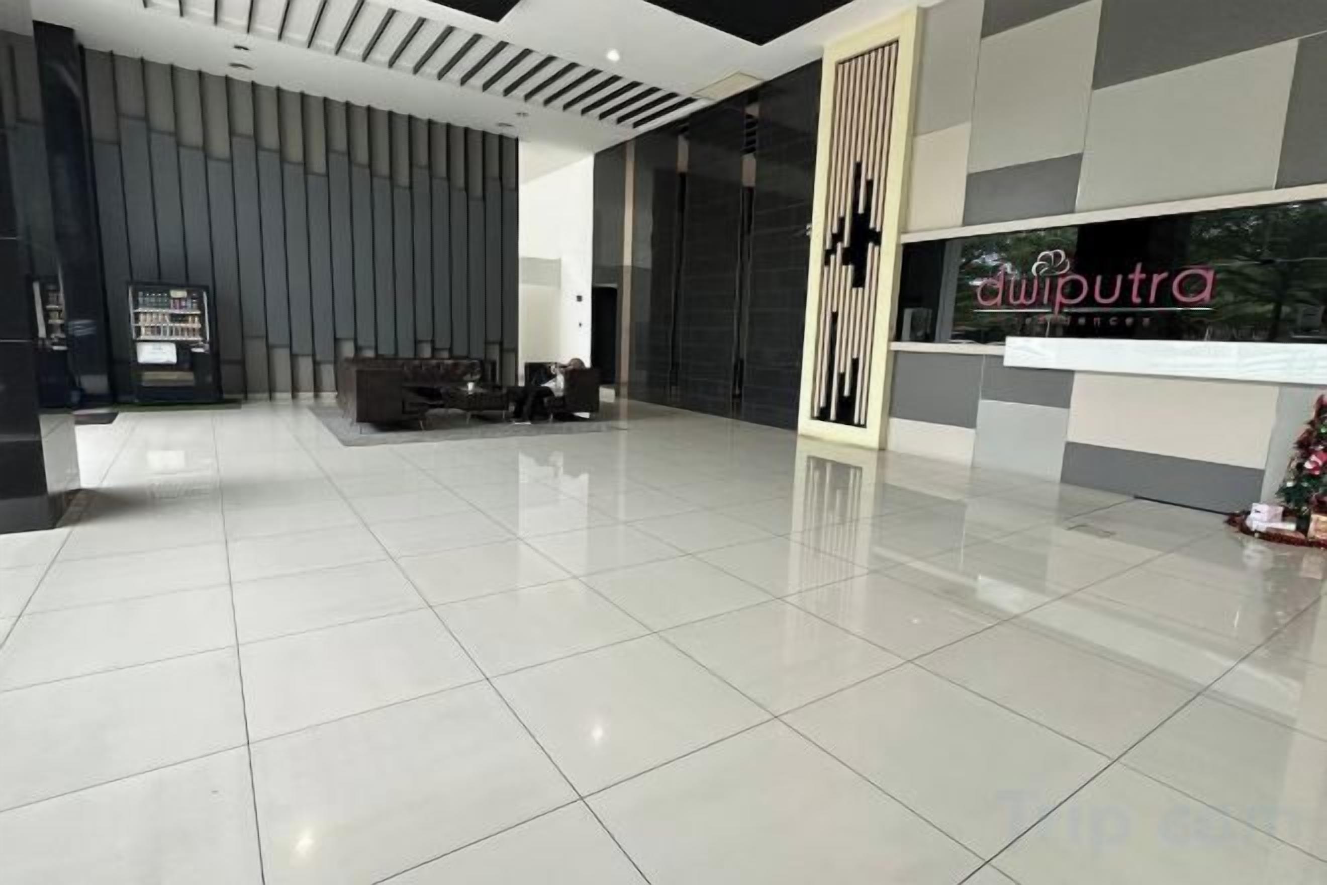 Um lobby moderno com uma mesa de recepção, área de estar e uma grande janela.