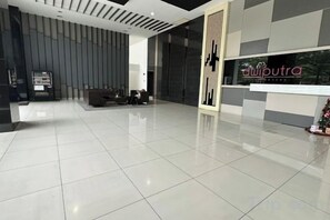 A modern lobby with a reception desk, a seating area, and a large window. - Casa Budi Dwiputra 15 Putrajaya (Putrajaya)