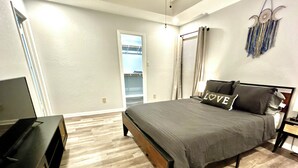 A bedroom with a bed, a TV, and a wardrobe.