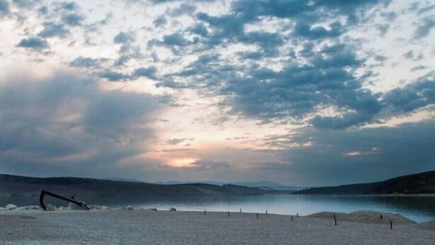 A coastal landscape with a pebbled beach, a calm sea, and a cloudy sky. - 14Person Combination Apartment 4 Apartments Combined (Jadranovo)