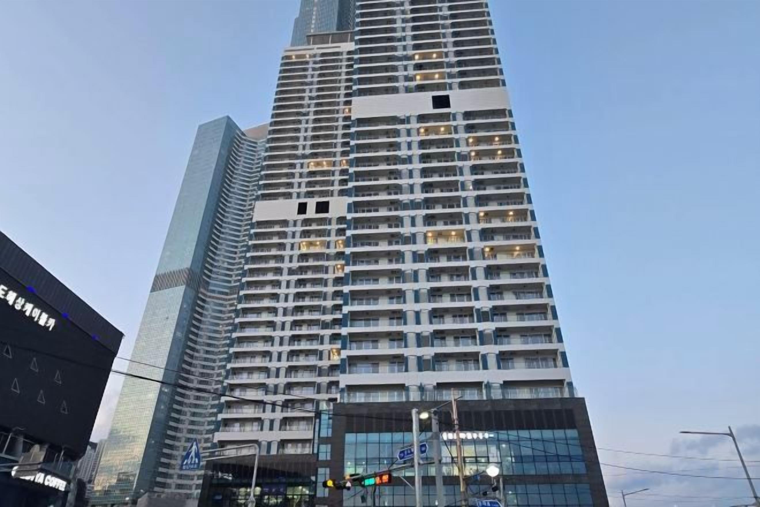 A high-rise building with multiple floors, large windows, and a modern architectural design.