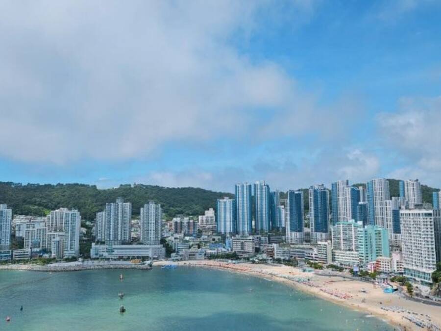 Un paisaje urbano costero con edificios altos, una playa y cielos despejados.