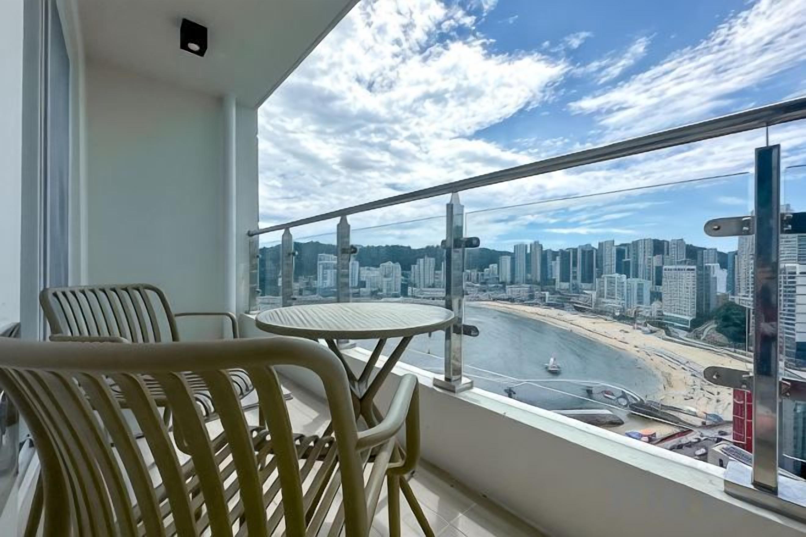 A balcony with a view of a city skyline and a beach.