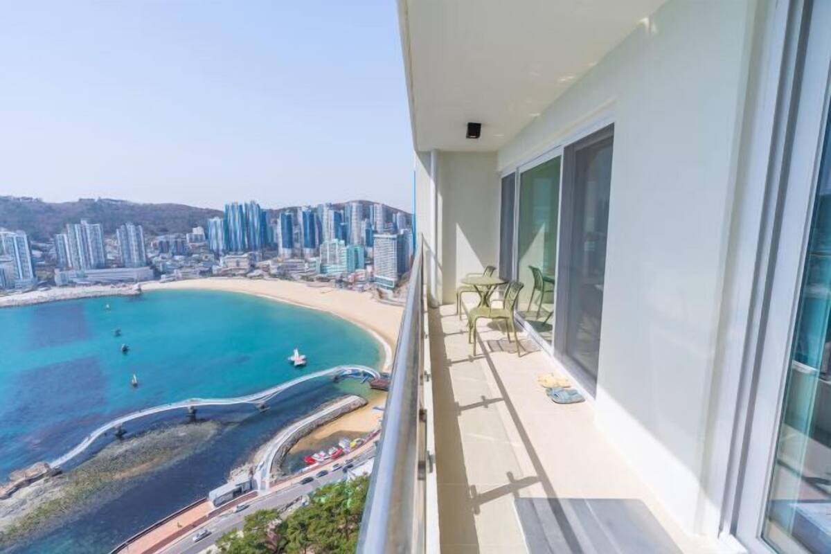 A balcony with a view of a beach and high-rise buildings.