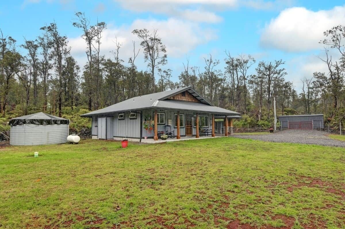 Une maison de plain-pied dotée d’une grande véranda, d’un espace extérieur couvert aménagé en salon et d’une cour clôturée.