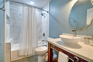 A bathroom with a bathtub, toilet, and sink. - Your Cozy Aloha Room (Royal Hawaiian Estates)