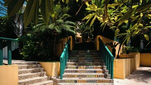 A staircase with colorful tiles leading up to a building, surrounded by greenery. - Bungalows Oasis (Brisas de Zicatela)
