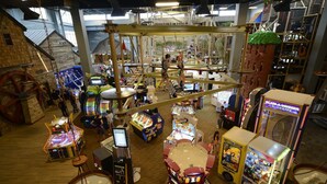 Un salón de juegos cubierto con diversos juegos y una noria.