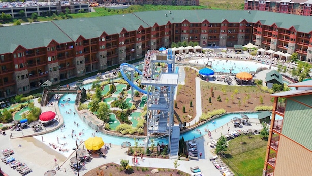 Un hotel con un amplio espacio de piscina, un tobogán acuático y varios niveles de balcones.