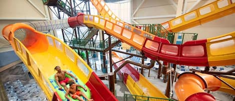 Un parc aquatique intérieur doté de plusieurs toboggans et d’un espace piscine.