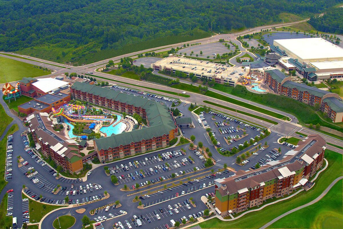 Een groot hotelcomplex met meerdere parkeerplaatsen, een zwembad en een waterpark.