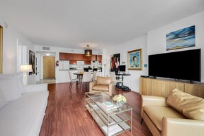 A modern living room with a sofa, a glass coffee table, and a television. - Suarez Art Stay, Brickell Bay View, Pool, Gym (Miami)