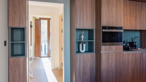 Une cuisine moderne avec des meubles en bois, des étagères intégrées et un four en acier inoxydable.