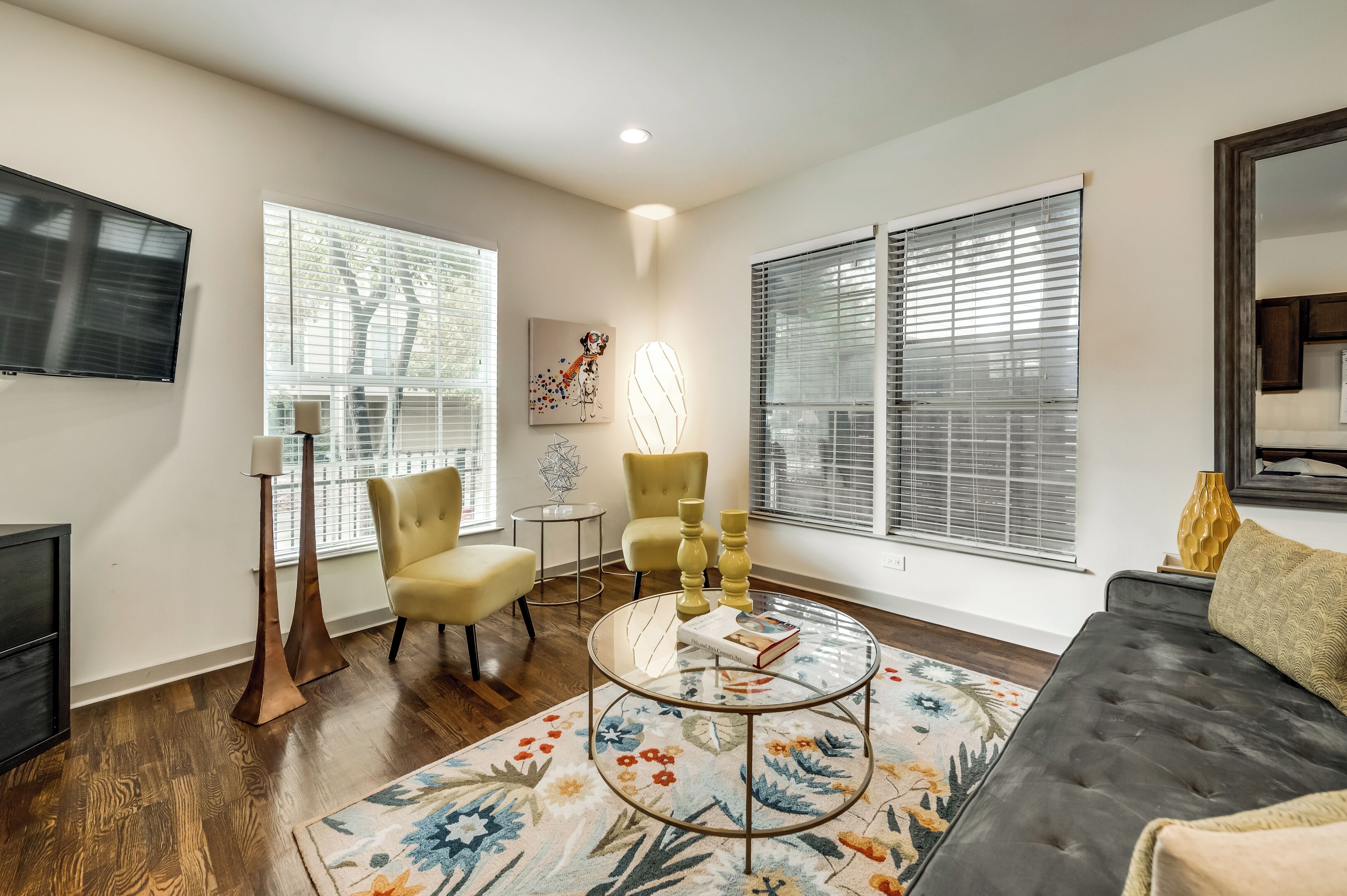 Un salon avec un canapé, deux fauteuils, une table basse et un téléviseur.