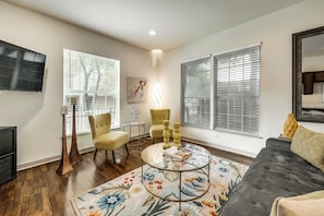 Una sala de estar con un sofá, dos sillones, una mesa de centro y un televisor.
