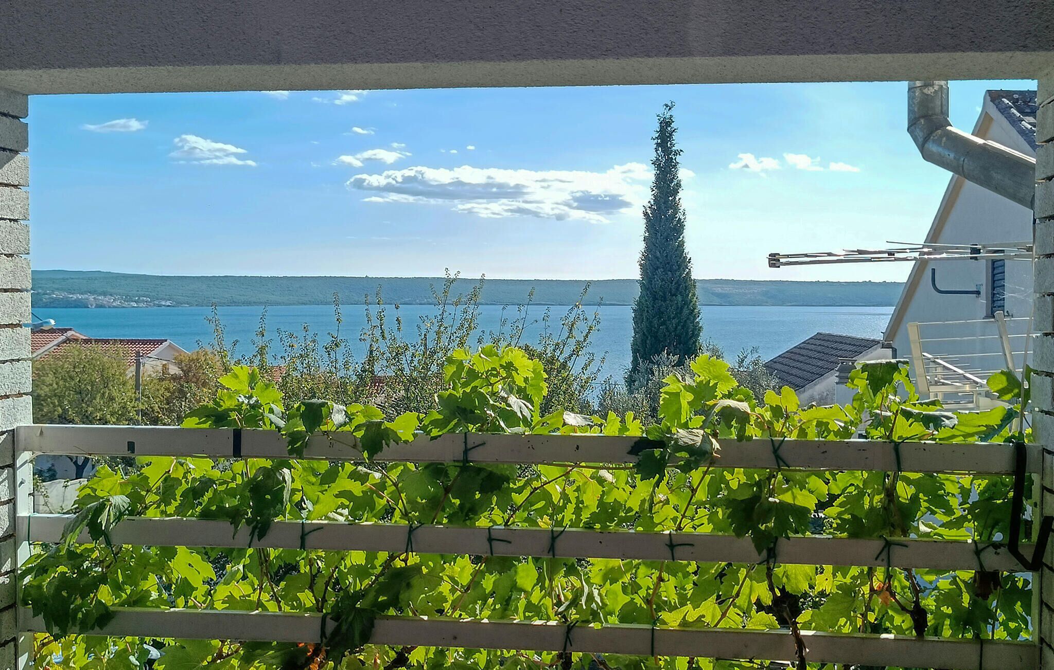 Ein Balkon mit Blick auf einen See und sanfte Hügel in der Ferne.
