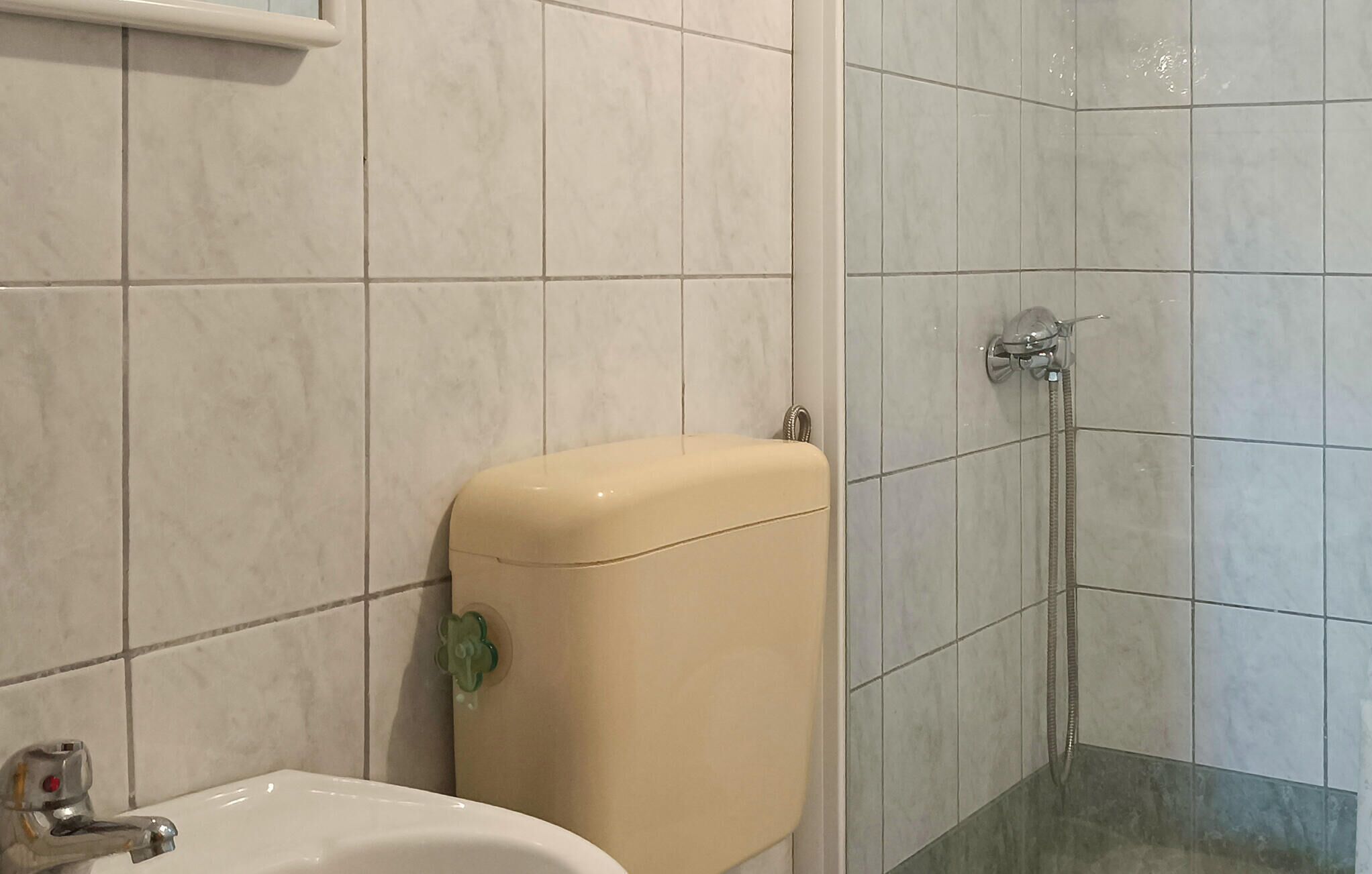 A bathroom with a toilet, sink, and shower.