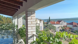 A residential area with a stone pillar, a pool, and houses with red roofs. - Lovely apartment in Maslenica with WiFi (Maslenica)