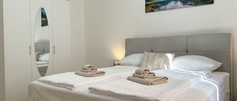A bedroom with a bed, a wardrobe, and a painting on the wall.