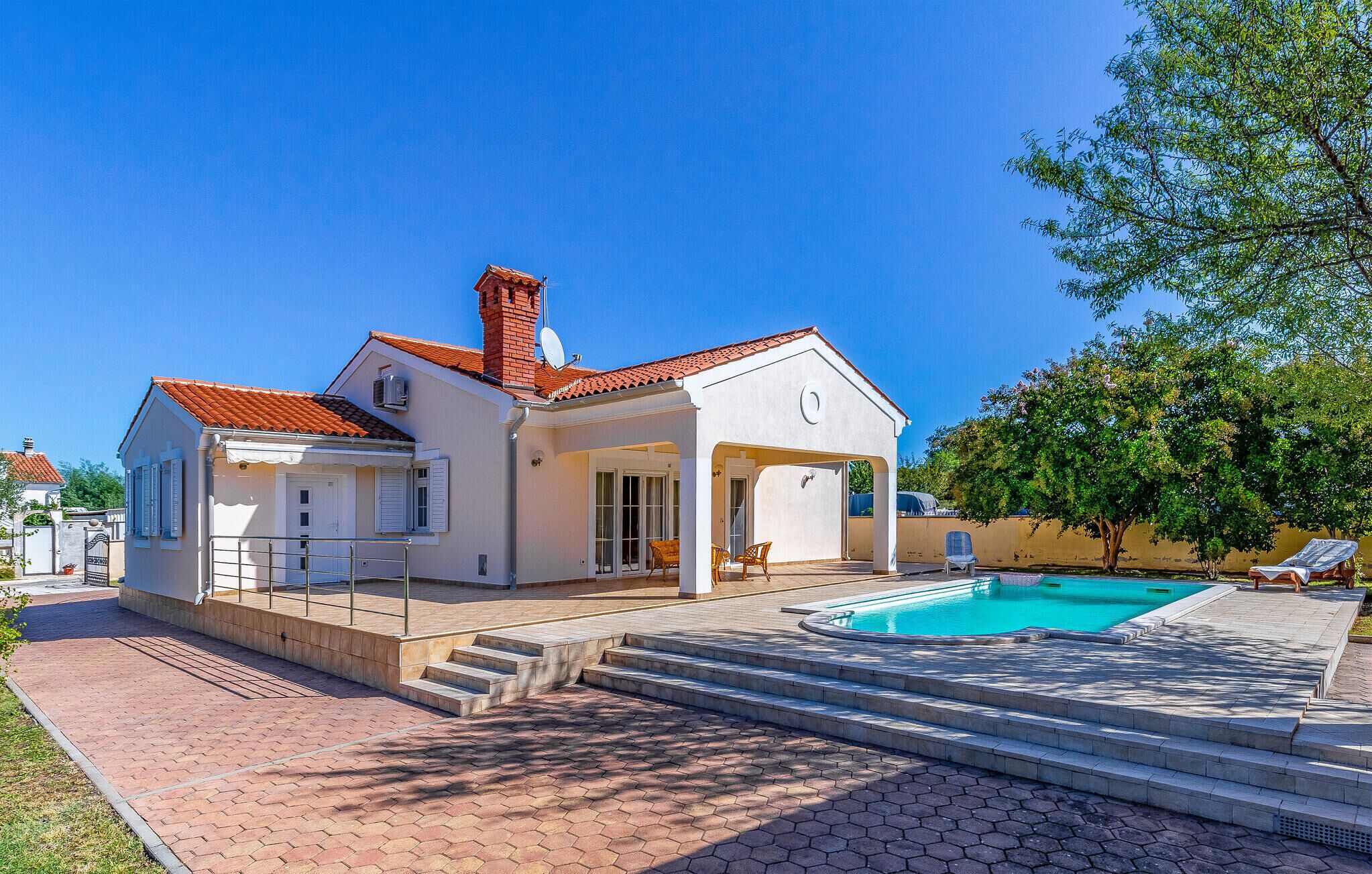 A two-story house with a swimming pool, a covered patio, and a garden.