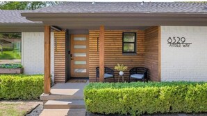 Une maison moderne avec une façade en bois, une porte d’entrée et une boîte aux lettres.