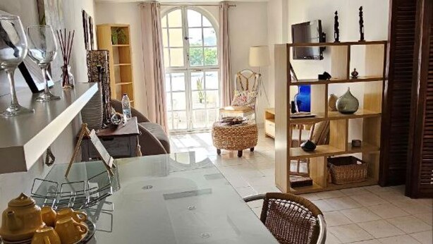 Un amplio espacio de estar con una mesa de comedor, sillas y un gran ventanal.