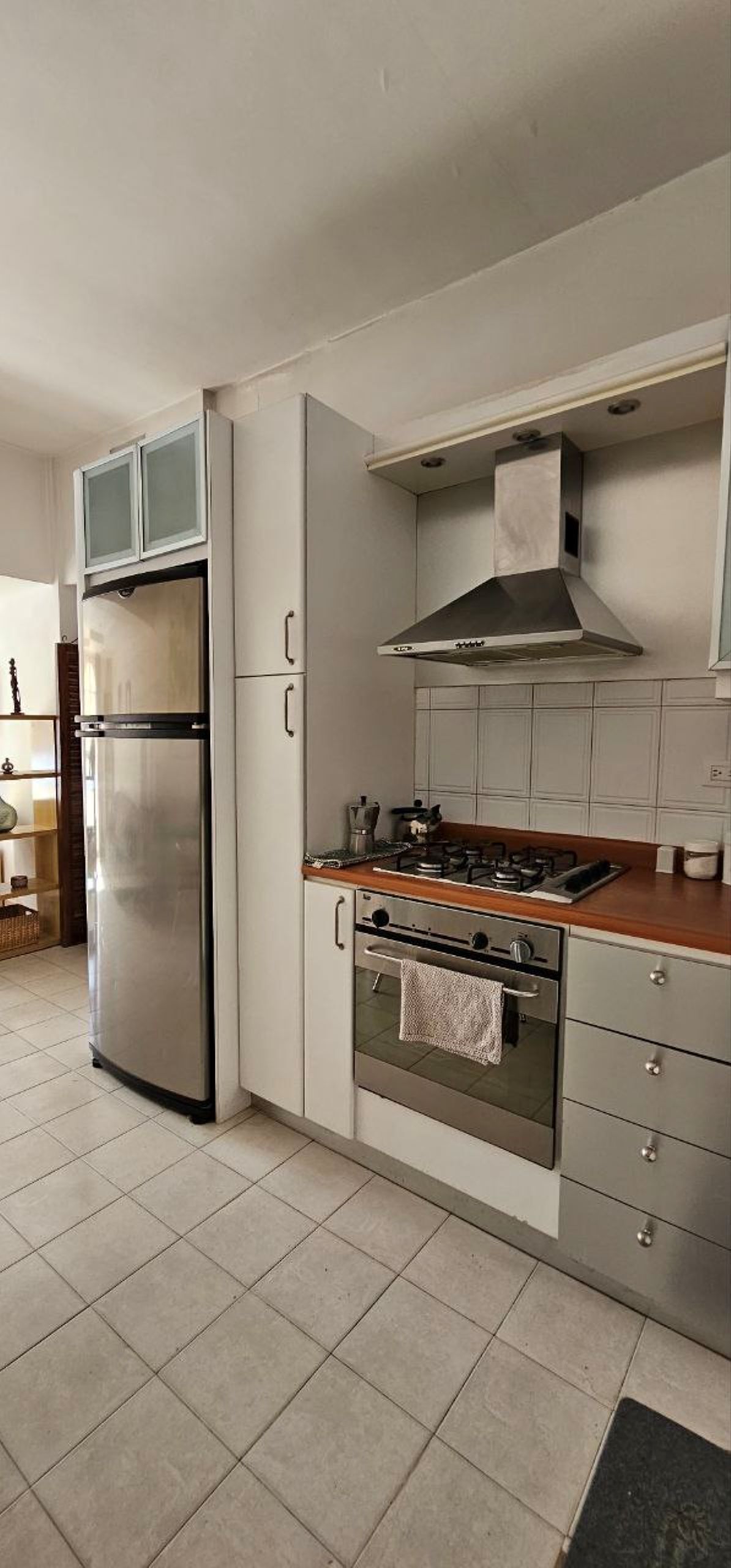 Una cucina moderna con frigorifero in acciaio inossidabile, piano cottura a gas e forno integrato.