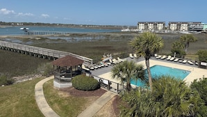Ein Resort mit Pool, Liegestühlen, einer Terrasse und Blick auf Strand und Meer.