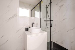 Regadera, secadora de cabello, papel de baño 