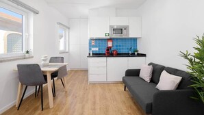 A compact living space with a kitchenette, a dining area, and a seating area. - Riverside Studio By Luís Bridge, WOW & Half Rabbit (Vila Nova de Gaia)
