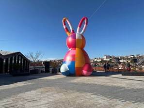 A large, colorful inflatable structure resembling a bunny in an urban setting.