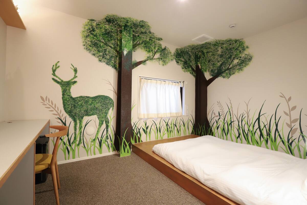 Ein Schlafzimmer mit einem Bett, einem Schreibtisch und einem Fenster mit Vorhängen.