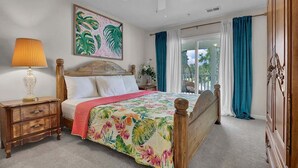 Ein Schlafzimmer mit einem hölzernen Bett, einem Nachttisch, einer Lampe, einem Deckenventilator und einem Fenster mit Vorhängen.
