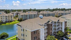 Un complejo residencial con varios edificios de apartamentos, un patio central y una masa de agua.