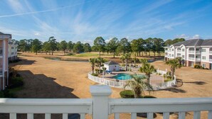 A golf course with a pool and a white fence.