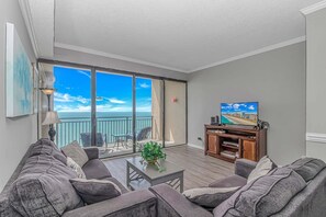 A living room with a balcony, a television, and a coffee table.