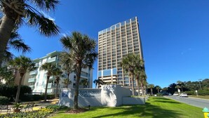 Un hotel de diseño moderno, con un edificio destacado que tiene un balcón y un letrero que indica el nombre y la dirección.