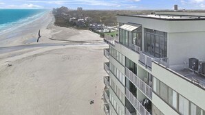 Un hôtel situé en bord de mer, doté de nombreux balcons offrant une vue sur l’océan.