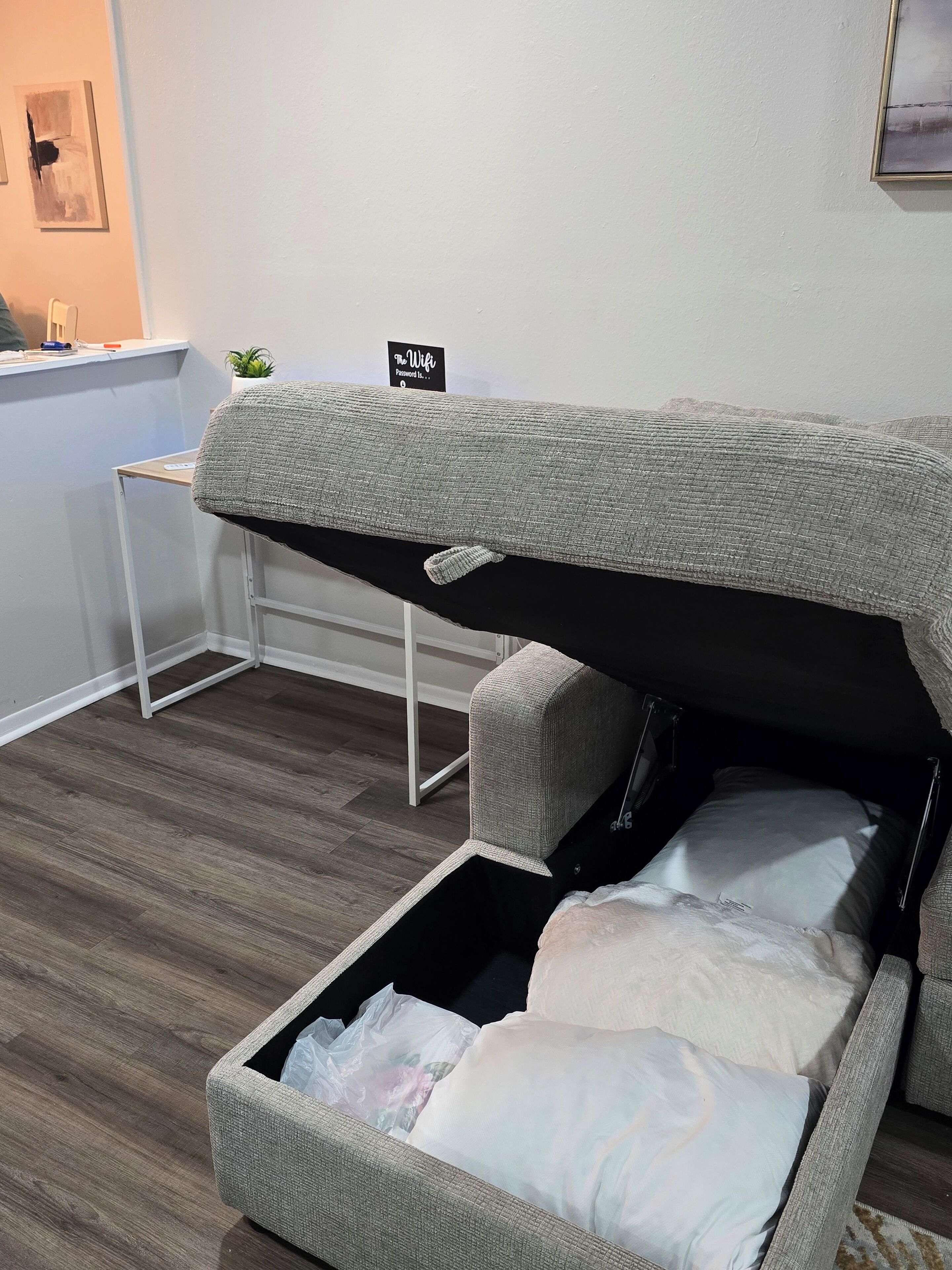 A compact room with a bunk bed, a small desk, and a sign indicating WiFi availability.