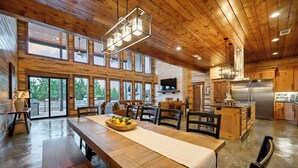 A spacious kitchen with wooden cabinets, a stainless steel refrigerator, and a large island. - The Unicorn - Featured on Staycation: Luxury Broken Bow Retreat (Broken Bow)