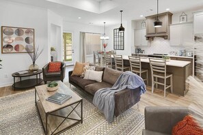 A modern living room with a sofa, coffee table, and dining area with chairs. - Modern Farmhouse Living @ Oakmont - 3Bed/3Bath (Bryan)