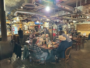 Un ristorante dall'atmosfera rustica, con tavoli in legno e diversi oggetti esposti alle pareti.
