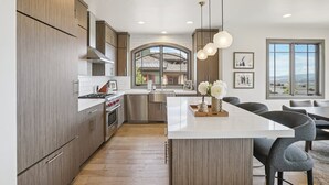Una cocina moderna con armarios de madera, electrodomésticos de acero inoxidable y una isla central.